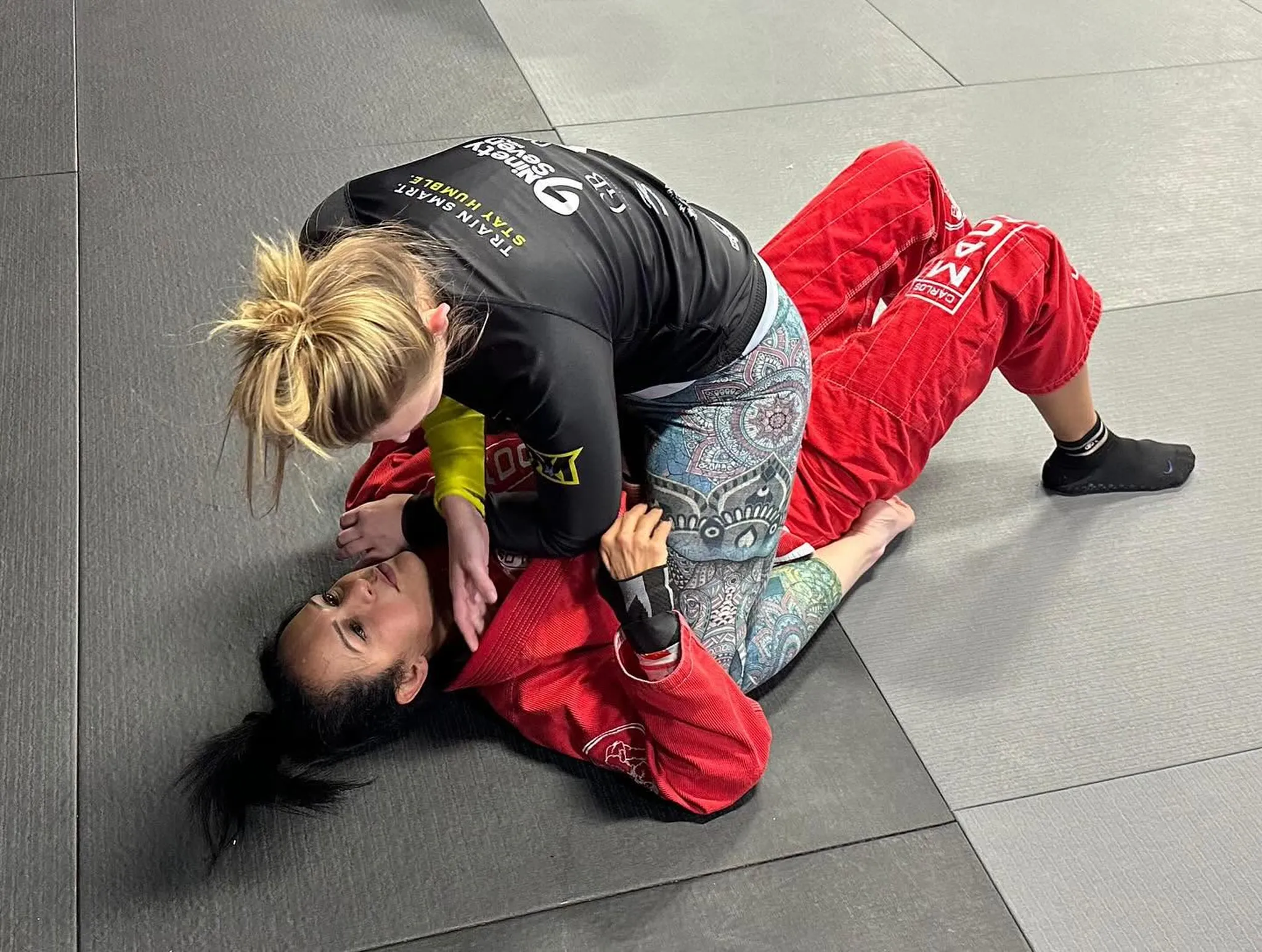 Two adult students drilling control positions during a Brazilian Jiu Jitsu class